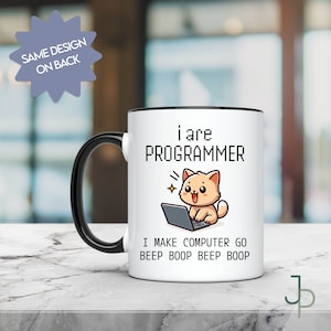 Pode incluir: Caneca de cerâmica branca com borda e alça pretas. A caneca apresenta um gato de desenho animado sentado em um laptop com o texto "i are PROGRAMMER" e "I MAKE COMPUTER GO BEEP BOOP BEEP BOOP".