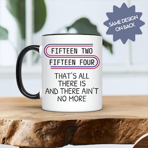 May include: White ceramic coffee mug with a black rim. The mug has the text "FIFTEEN TWO FIFTEEN FOUR THAT'S ALL THERE IS AND THERE AIN'T NO MORE" printed on it in black. The text is in a bold font. The mug has a black handle.