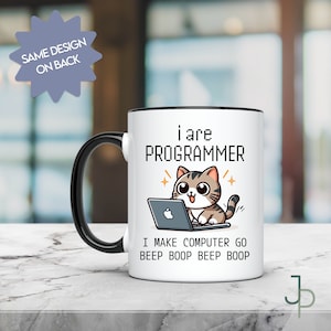 Pode incluir: Caneca de cerâmica branca com alça e borda pretas. A caneca apresenta um gato de desenho animado usando um laptop, com o texto "i are PROGRAMMER" e "I MAKE COMPUTER GO BEEP BOOP BEEP BOOP". O design está em ambos os lados.