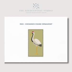 May include: A digital image of a Red-Crowned Crane ornament. The crane is depicted in a pixelated style, with a red crown, black neck, and white body. The crane stands on yellow legs against a light green background, framed by a black and white border. The text "RED - CROWNED CRANE ORNAMENT" is above the image.