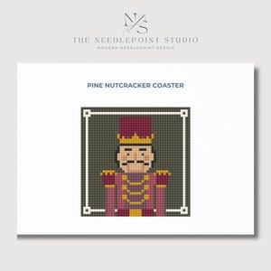May include: A needlepoint pattern for a coaster featuring a pixelated image of a nutcracker in a red and gold uniform with a green background. The text "PINE NUTCRACKER COASTER" is at the top of the image.