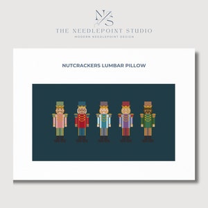 Peut inclure: Un motif de point d'aiguille représentant cinq personnages de casse-noisette colorés sur un fond bleu foncé. Le motif est intitulé "Nutcrackers Lumbar Pillow".