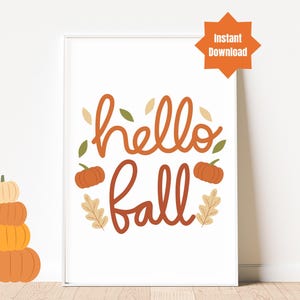 Könnte beinhalten: Druckbare Wandkunst mit dem Text "hello fall" in orangefarbener und brauner Schrift mit einem dekorativen Rand aus Blättern und Kürbissen.