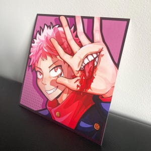 May include: A square art print featuring a stylized anime character with spiky pink hair and red eyes. The character holds a hand up, revealing a mouth with white teeth and a red tongue emerging from the palm, accented by bright red blood splatter.