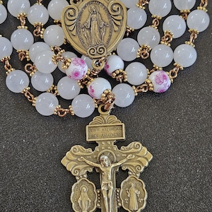 R089- Handmade rosary. White jade glass beads .  Ornate centerpiece. Ceramic floral beads.  Repentance cross.   Vintage bronze rosary.