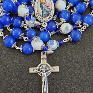 R087- Handmade Rosary. Royal blue glass beads. Decade bead is floral ceramic bead. Ornate crucifix. Enamel Mary of the streets. Chaple