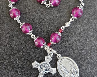 TR001- Handmade tenner decade pocket rosary.  Plum or magenta colored glass beaded chaplet .  Medal is of Fatima and Sacred heart of Jesus.