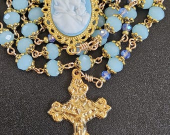 R188-  Handmade rosary.  Light Marian blue  facetted milk glass beads .  Mary of the Street cameo. Golden rosary. ornate crucifix.