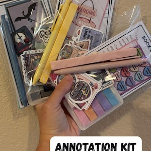 May include: An annotation kit containing pens, stickers, sticky notes, and review cards. The kit includes yellow and pink pens, various stickers with book-related designs, and a small container of colorful sticky notes. The text "ANNOTATION KIT" is visible.