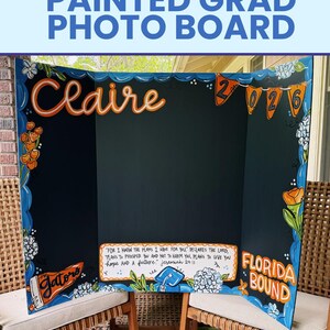 May include: A tri-fold black display board featuring hand-painted orange and blue floral accents, the name Claire, the year 2026, a Gators pennant, and the text Florida Bound. A central box contains the Bible verse Jeremiah 29:11 in black lettering.
