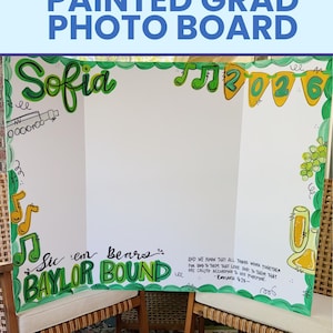 May include: A white tri-fold display board featuring hand-painted green and yellow decorations. The board includes the name Sofia, the text Sic 'em Bears BAYLOR BOUND, a 2026 banner, musical notes, grapes, and the Bible verse Romans 8:28.
