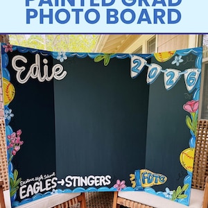 May include: A tri-fold display board with a dark background featuring hand-painted decorations including the name Edie, the year 2026 on pennants, yellow softballs, flowers, and the text Eastern High School EAGLES -> STINGERS and FDTC.