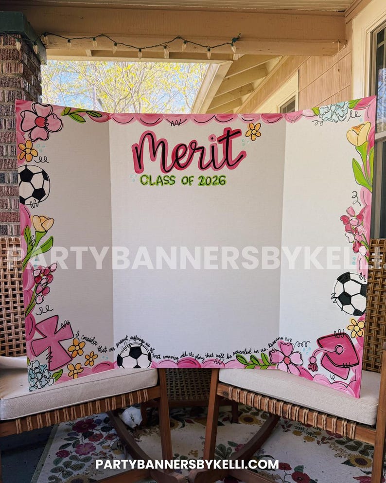 May include: A white tri-fold display board featuring hand-painted pink and green floral borders, footballs, a pink cross, and a graduation cap. The text reads Merit CLASS OF 2026 in pink and green, with a Bible verse written along the bottom edge.