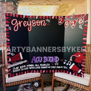 May include: A black tri-fold display board with red and white painted borders. It features the name Greyson, the year 2026 in pennants, a graduation cap, megaphones, and the text ACU BOUND with the Bible verse Psalm 47:1 in white lettering.