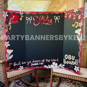 May include: A tri-fold black display board featuring hand-painted red and white floral borders, musical notes, and a graduation cap. The board displays the name Elle, the year 2026, the text But be ye doers of the Word. JAMES 1:22, and OBU Bound!