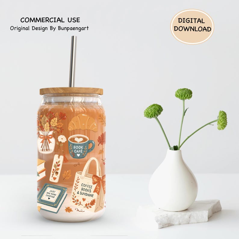 May include: A clear glass tumbler with a wooden lid and metal straw, featuring a printed design of autumn leaves, a croissant, a coffee mug labeled Book Cafe, a bookmark, a book labeled Just One More Chapter, and a tote bag labeled Coffee Books & Sunshine.