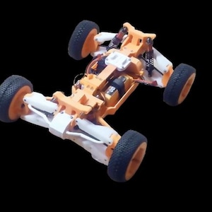 Könnte beinhalten: Ein orangefarbenes und weißes 3D-gedrucktes Chassis für ein ferngesteuertes Auto. Das Chassis hat vier Räder und einen Motor.