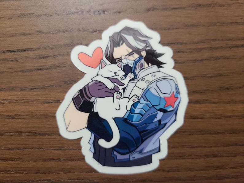 May include: A sticker featuring an anime-style character in a blue and silver armored suit holding a white cat. A red heart floats above the cat. The sticker has a white border.