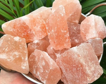 Puede incluir: Un bol de grandes cristales de sal rosa del Himalaya, rugosos. Los cristales de sal son de diversas formas y tamaños.