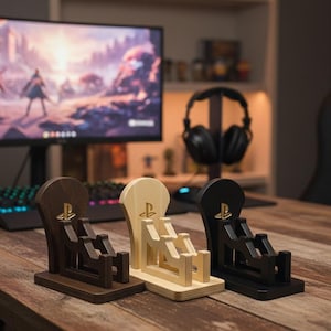 Può includere: Tre supporti in legno per console di gioco marroni, naturali e neri. Ogni supporto presenta un logo PlayStation e un design a culla per contenere un controller. I supporti sono esposti su una scrivania di legno.