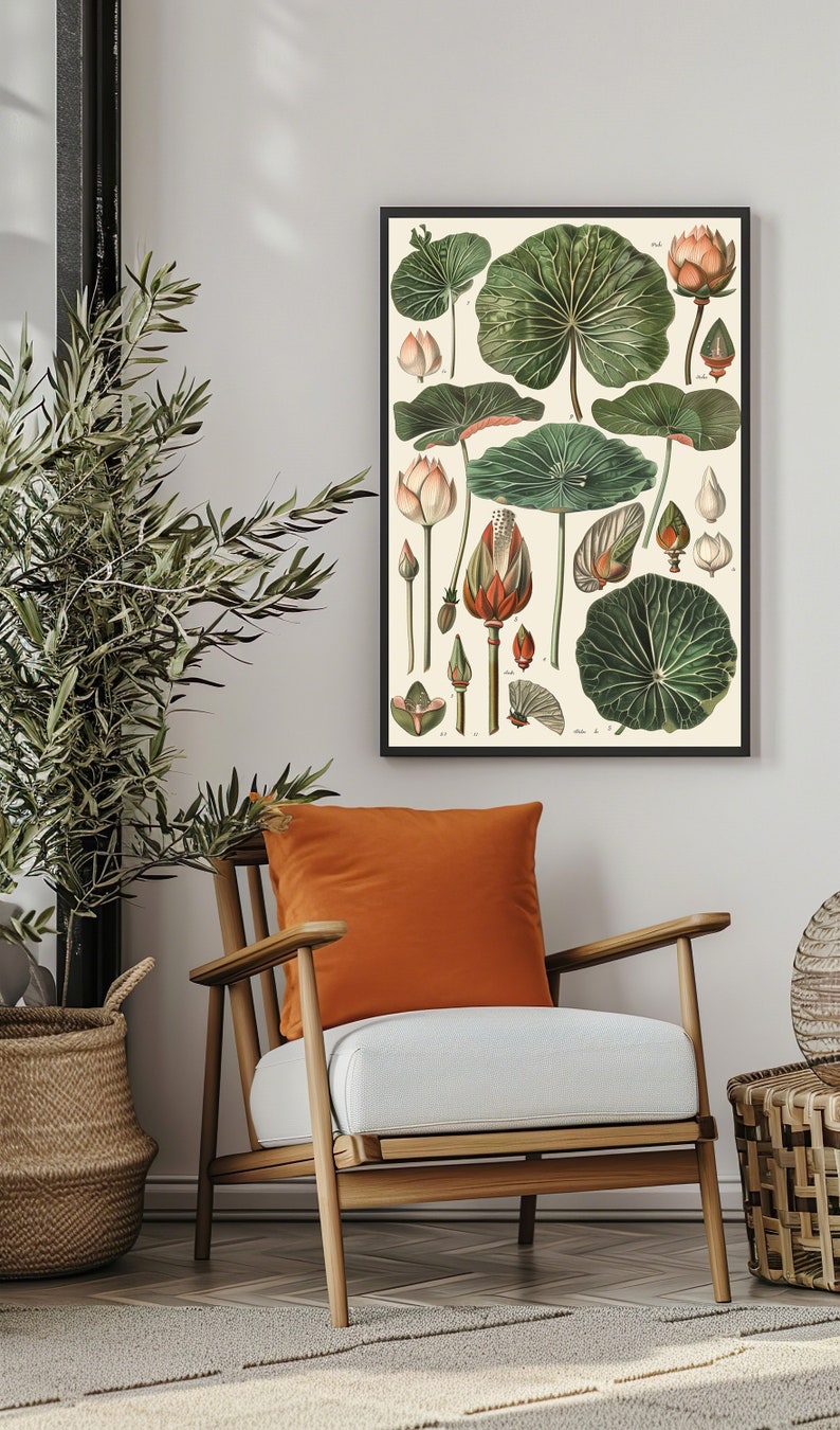 May include: Botanical print featuring detailed illustrations of various plant parts, including leaves, buds, and flowers, in shades of green, beige, and orange. The artwork is framed in a black frame and displayed in a living room setting with a wooden chair and orange pillow.