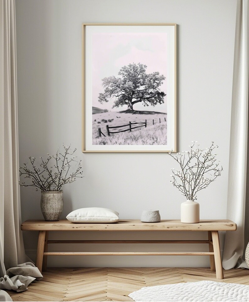 May include: A black and white photograph of a lone tree in a field with a wooden fence. The sky is a light pink color.