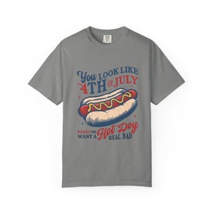K&ouml;nnte beinhalten: Graues T-Shirt mit einer Abbildung eines Hotdogs und dem Text "You look like the 4th of July, makes me want a hot dog real bad." Der Hotdog ist rot, gelb und wei&szlig;.