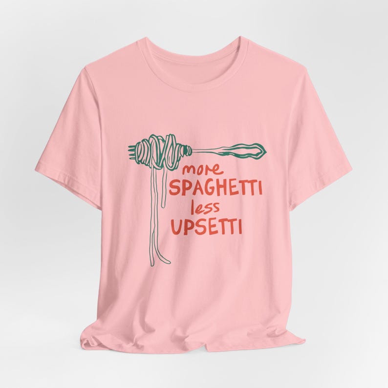 May include: Pink t-shirt with a green and red illustration of spaghetti on a fork and the text "more spaghetti less upsetti"