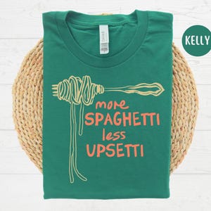 May include: Green t-shirt with a white spaghetti graphic and the text "more spaghetti less upsetti".