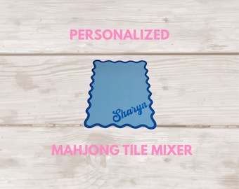 May include: A blue rectangular mahjong tile mixer with a scalloped edge and the name Sharyn printed in a dark blue script font. The image includes the pink text PERSONALIZED and MAHJONG TILE MIXER, with a logo reading SGfts by Sharyn Gustaves.