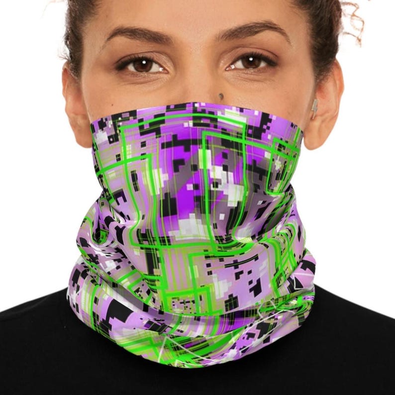K&ouml;nnte beinhalten: Ein Gesichtsschutz mit einem lebendigen, geometrischen Design. Das Muster zeigt eine Mischung aus lila, gr&uuml;nen, schwarzen und wei&szlig;en Quadraten und Linien. Der Stoff ist um das untere Gesicht gewickelt und bedeckt Nase und Mund.