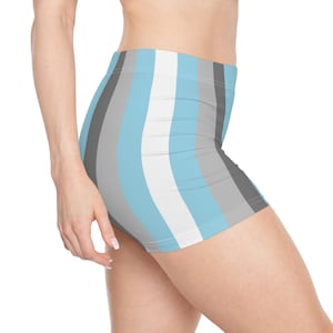 May include: A pair of high-waisted shorts with vertical stripes in light blue, white, gray, and black. The shorts are form-fitting and made of a stretchy material. The shorts are designed for athletic activities or casual wear.