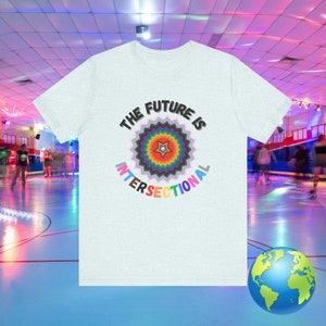 May include: A light grey t-shirt with a colorful graphic design that says "The Future is Intersectional". The graphic features a rainbow starburst with a star in the center.