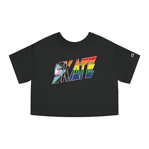 May include: Black crop top with the word "SKATE" in a rainbow-colored, Pride-themed design. The shirt has a crew neck and short sleeves. The Champion logo is visible on the left sleeve.
