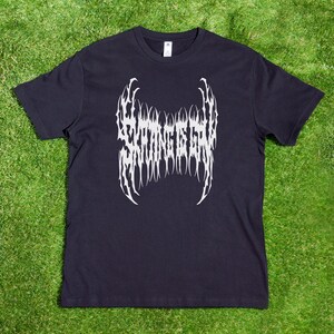 May include: Black t-shirt with a white graphic of the text "Strong is the New Sexy" in a stylized font.