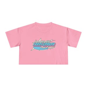 May include: Pink cropped t-shirt with a retro-style graphic that says "I love my Transgender Partner" in blue and pink lettering.
