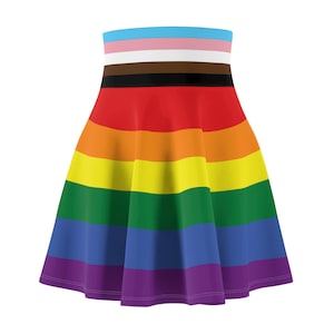 Può includere: Una gonna arcobaleno con una striscia bianca, rosa e celeste in alto. La gonna è realizzata in un tessuto morbido ed elastico e ha una silhouette svasata.