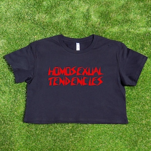 May include: A black cropped t-shirt with the text "HOMOSEXUAL TENDENCIES" printed in red.