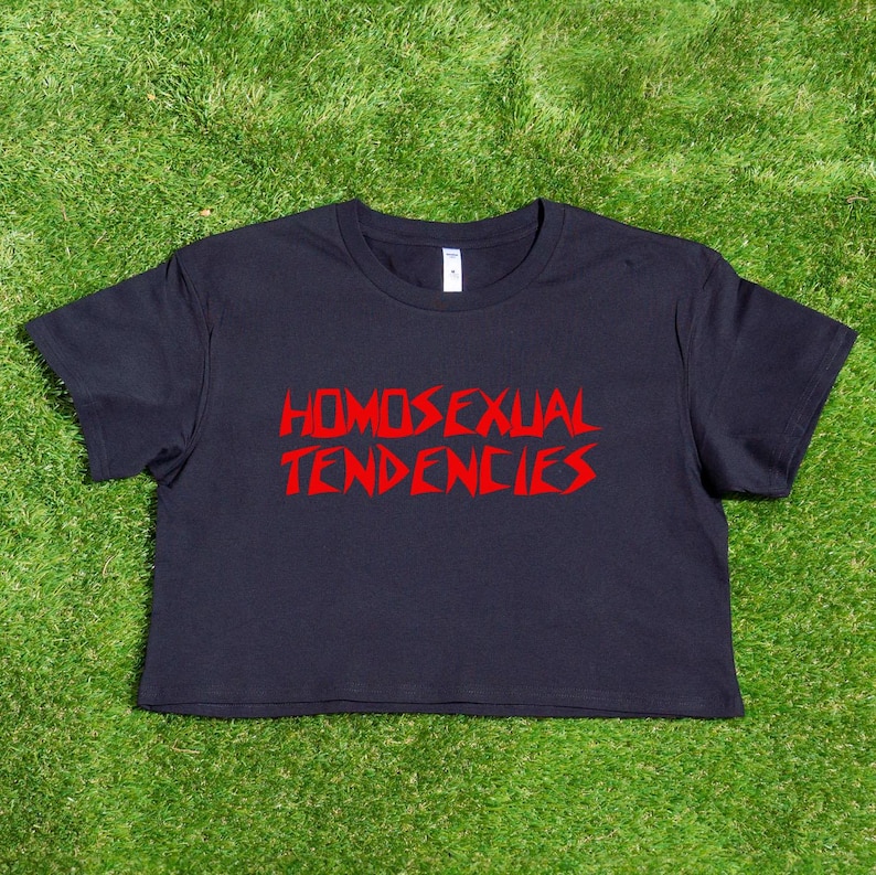 May include: A black cropped t-shirt with the text "HOMOSEXUAL TENDENCIES" printed in red.
