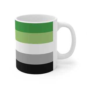 Puede incluir: Taza de cerámica blanca con el diseño de la bandera del orgullo arromántico. La bandera presenta franjas horizontales en verde, verde claro, blanco, gris y negro. La taza tiene un asa curvada y un acabado brillante.