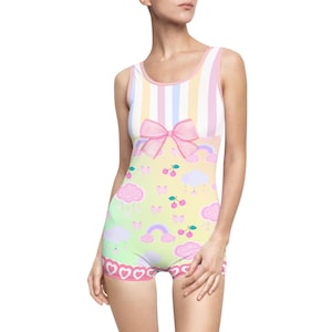 May include: A pink and yellow swimsuit with a rainbow, clouds, butterflies, and cherries print. The swimsuit has a pink bow at the top and a white stripe pattern.