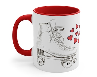 May include: White ceramic mug with a red interior. The mug features a black and white illustration of a roller skate with red hearts around it.
