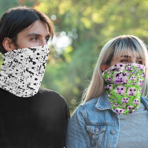 K&ouml;nnte beinhalten: Zwei Personen tragen Halst&uuml;cher. Einer hat ein wei&szlig;es und schwarzes Pixelmuster. Der andere hat ein gr&uuml;nes und rosa Pixelmuster. Beide Halst&uuml;cher bedecken das untere Gesicht und den Hals.