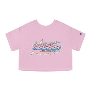 May include: Pink cropped t-shirt with a graphic design that says "I love my transgender girlfriend" in a retro comic book style.