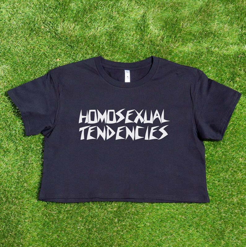 May include: A black cropped t-shirt with the text "HOMOSEXUAL TENDENCIES" printed in white.