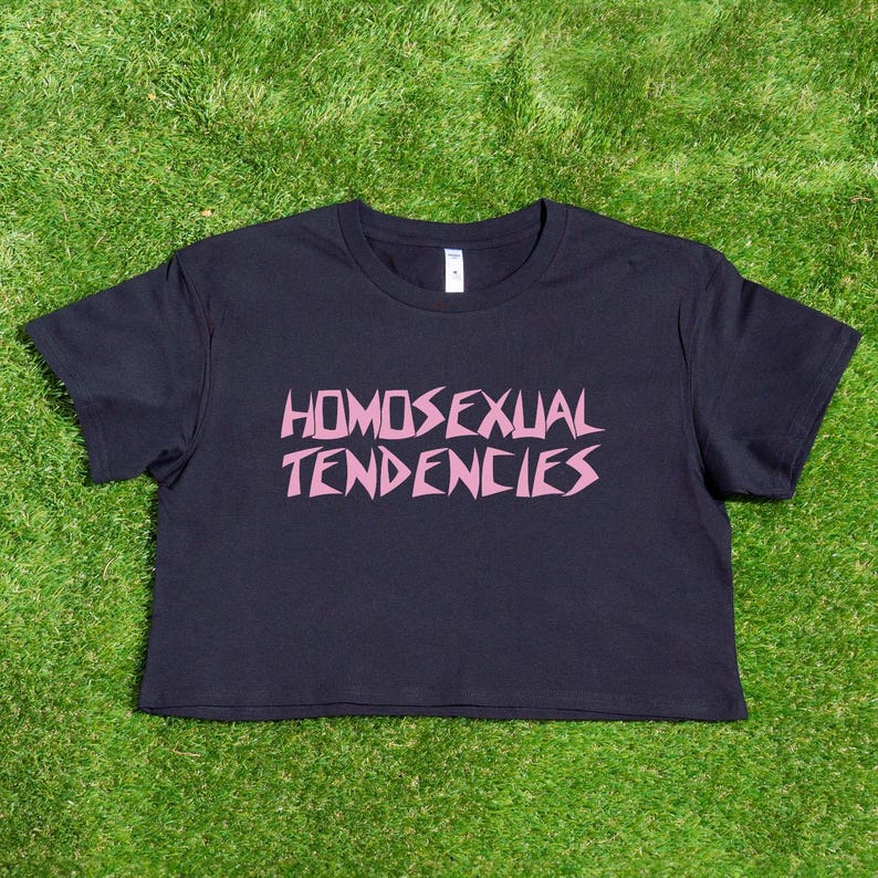 May include: A black cropped t-shirt with the phrase "HOMOSEXUAL TENDENCIES" printed in pink letters.