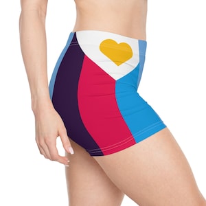 May include: Vibrant athletic shorts with a geometric pattern. The shorts have a white waistband with a yellow heart, and vertical stripes in blue, red, and purple. The shorts are made of a stretchy material.