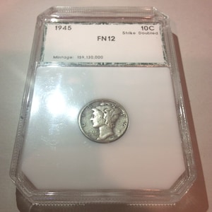 May include: A 1945 Mercury dime, graded FN12, housed in a protective plastic case. The coin features a profile of a woman wearing a winged Phrygian cap. The case includes details: "10C Strike Doubled" and a mintage of 159,130,000.