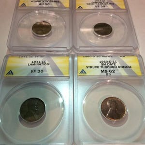 May include: Four encased vintage coins are displayed. The coins are in clear plastic holders with yellow labels. The labels include details such as the year, type, and condition of each coin. The coins are from 1953, 1944, 1941, and 1960.