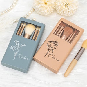 Peut inclure: Deux ensembles de pinceaux de maquillage personnalisés dans des étuis bleus et bruns avec des motifs floraux. Les étuis portent les noms "Mabel" et "Olivia" imprimés dessus.